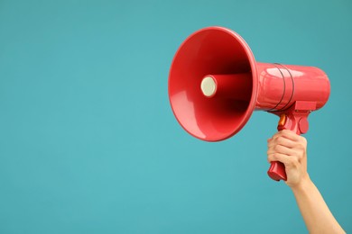 Photo of Woman holding megaphone speaker on blue background, closeup. Space for text