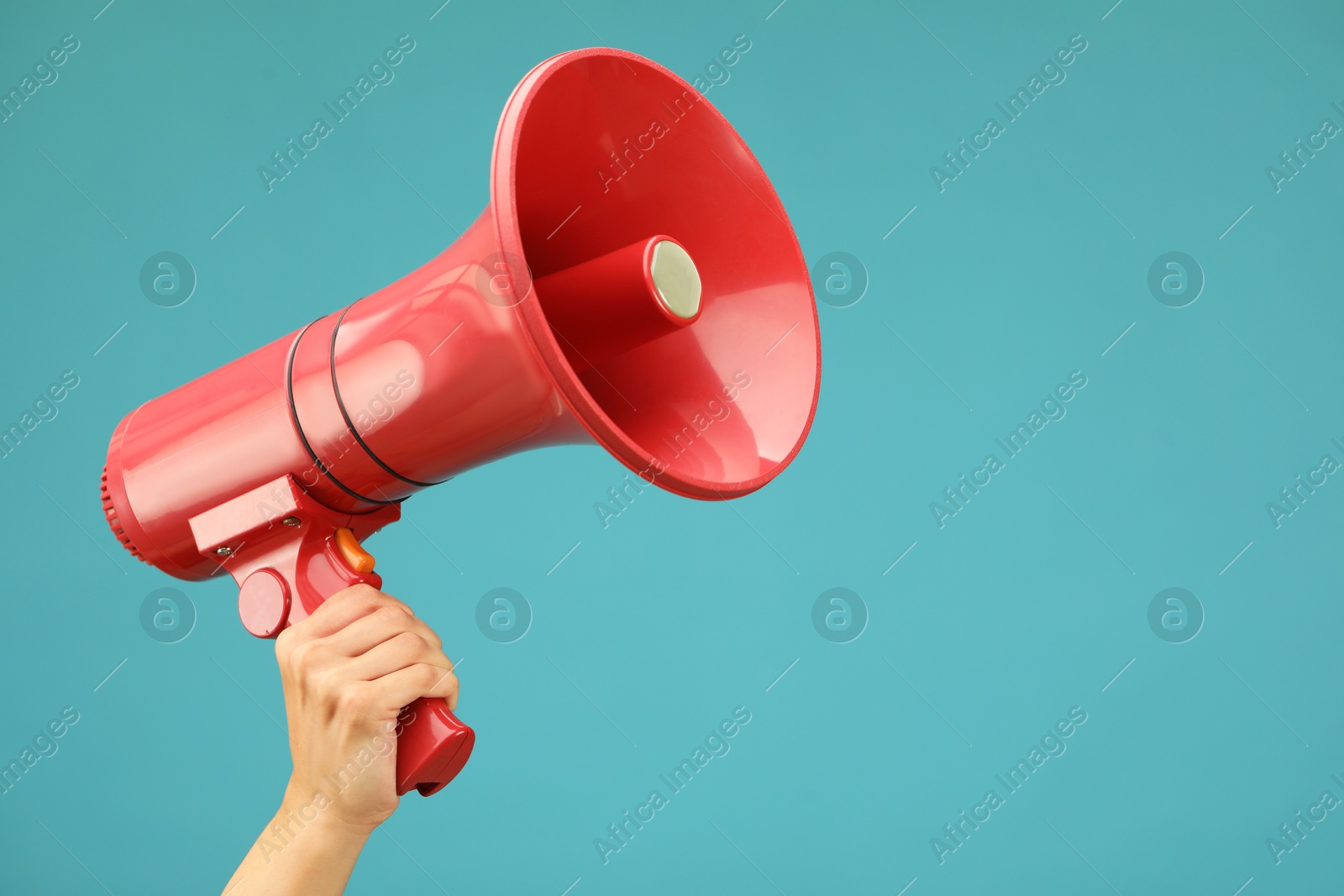 Photo of Woman holding megaphone speaker on blue background, closeup. Space for text