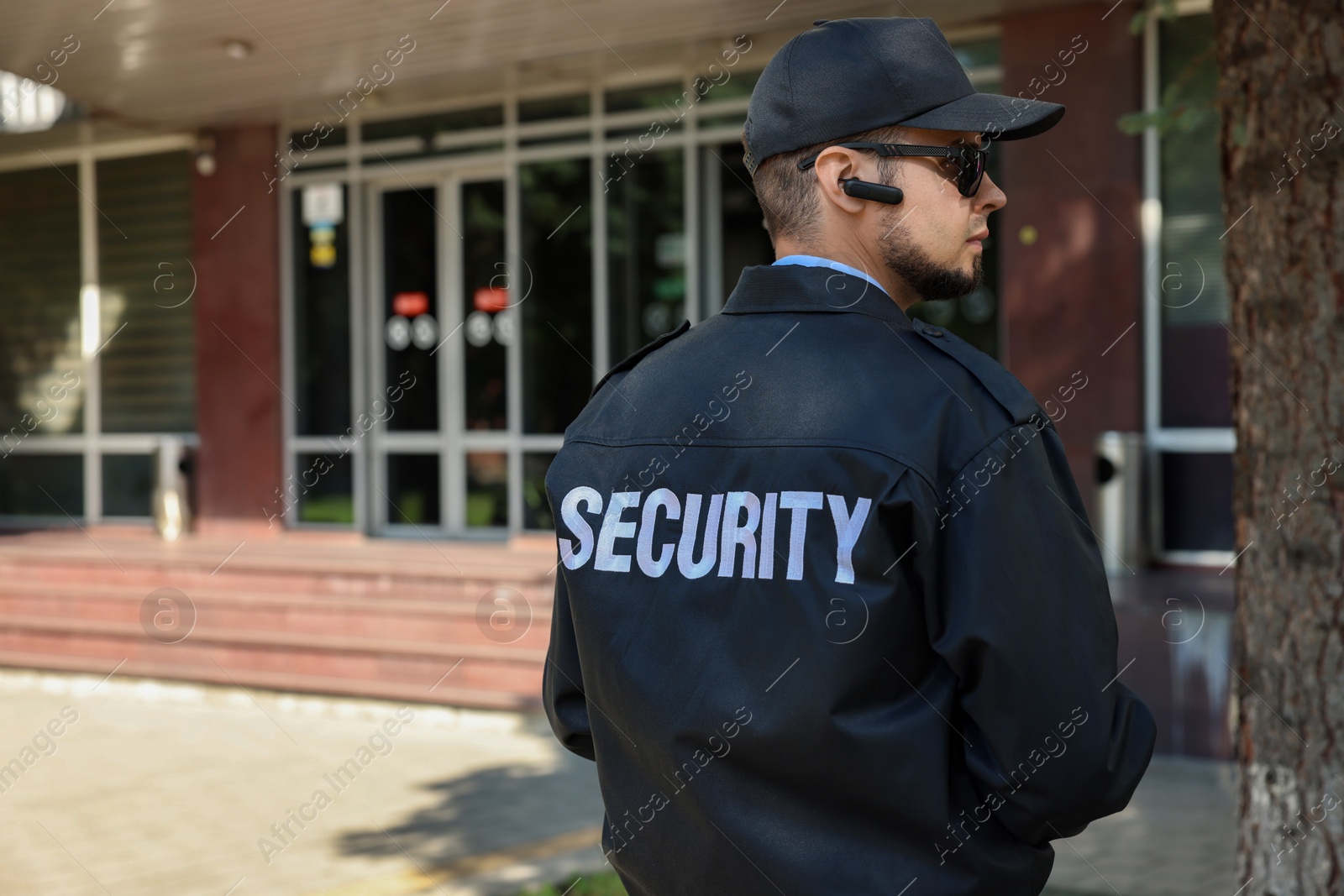 Photo of Security guard in uniform and sunglasses outdoors