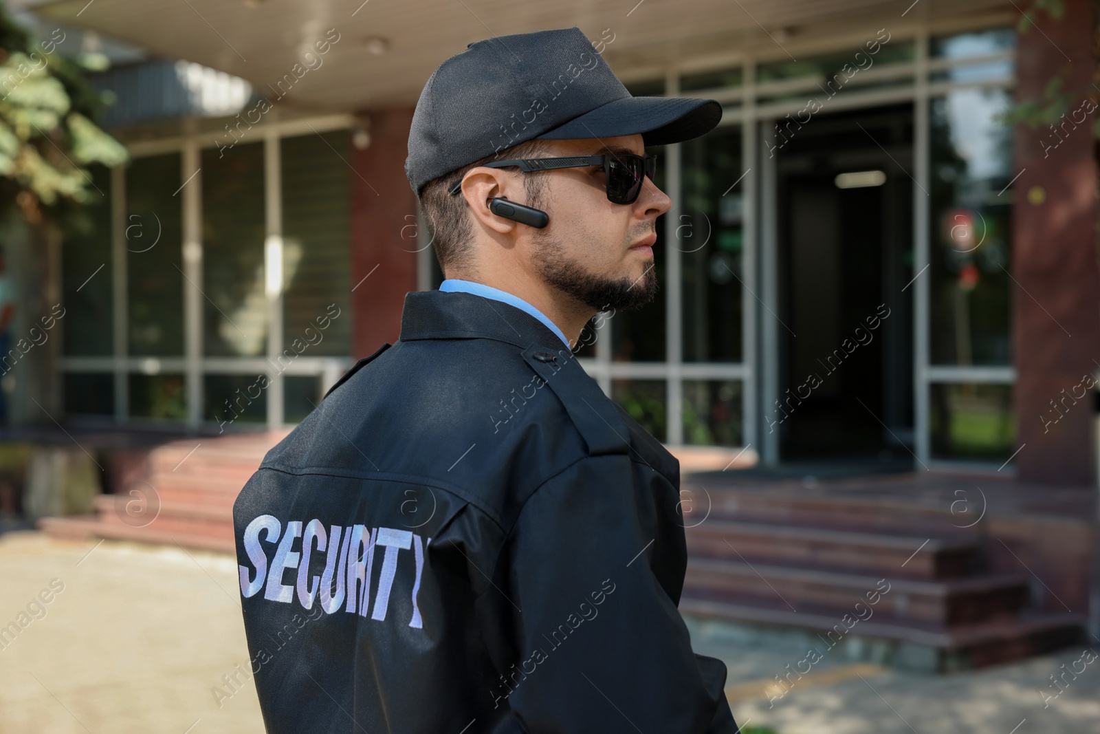 Photo of Security guard in uniform and sunglasses outdoors