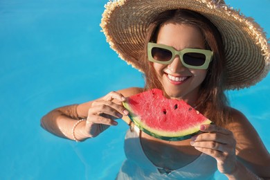 Happy woman with slice of juicy watermelon in swimming pool outdoors