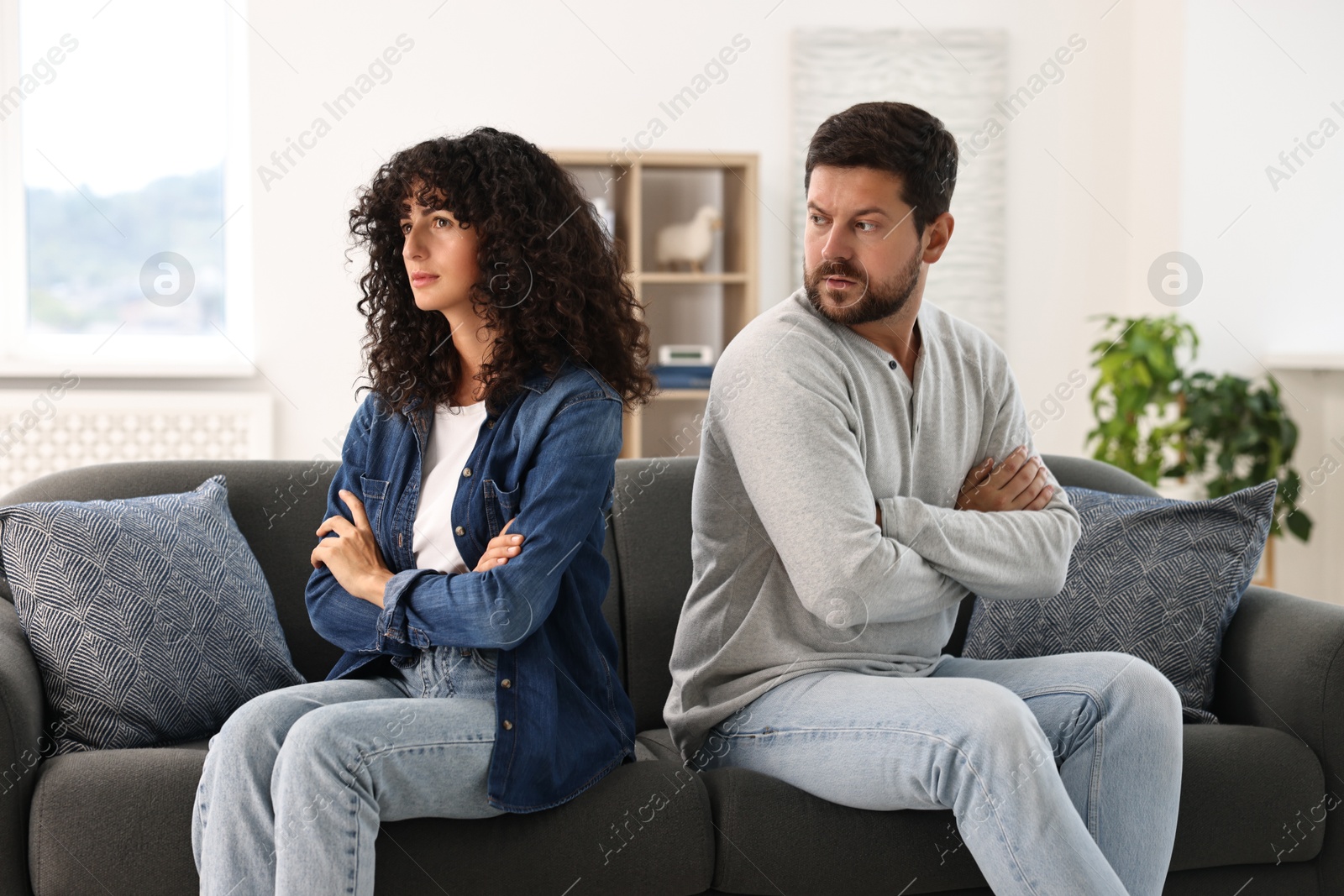 Photo of Emotional couple having quarrel on sofa at home. Relationship problems