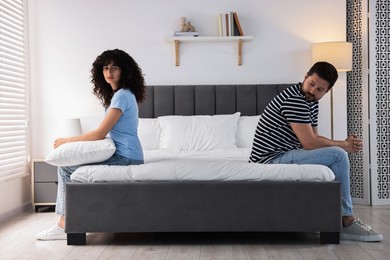 Photo of Couple having quarrel in bedroom. Relationship problems