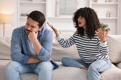 Photo of Emotional couple arguing on sofa at home. Relationship problems