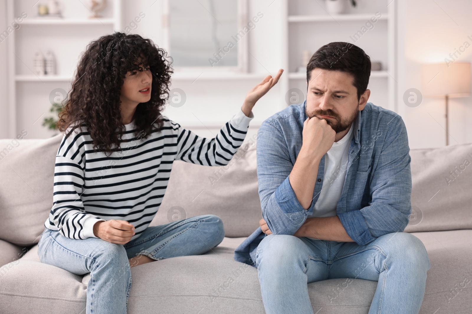 Photo of Emotional couple arguing on sofa at home. Relationship problems