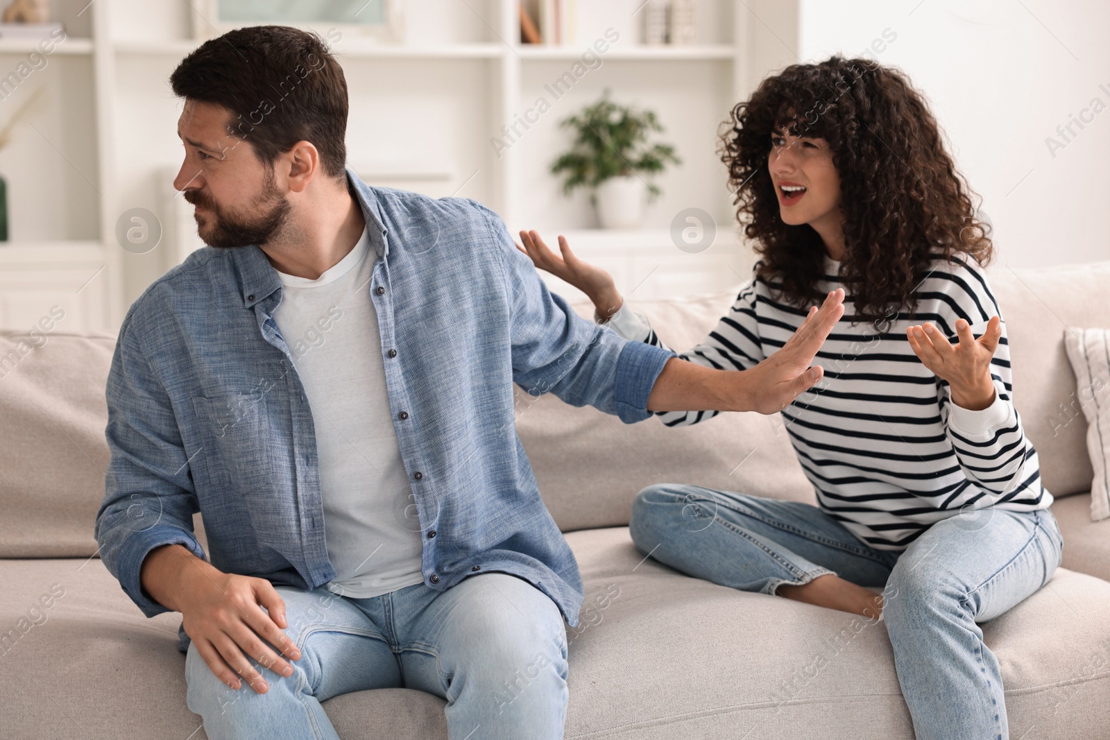 Photo of Emotional couple arguing on sofa at home. Relationship problems