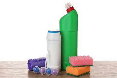 Photo of Different toilet cleaners, sponges and trash bags on wooden table against white background