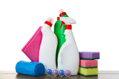 Photo of Different toilet cleaners, sponges, rag and trash bags on wooden table against white background