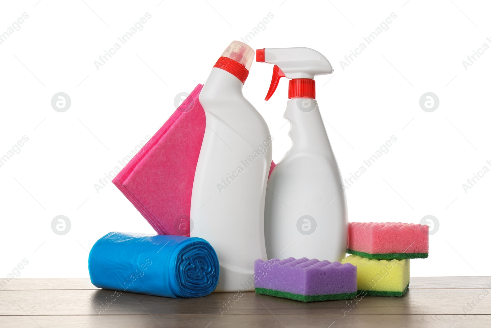 Photo of Different toilet cleaners, sponges, rag and trash bags on wooden table against white background