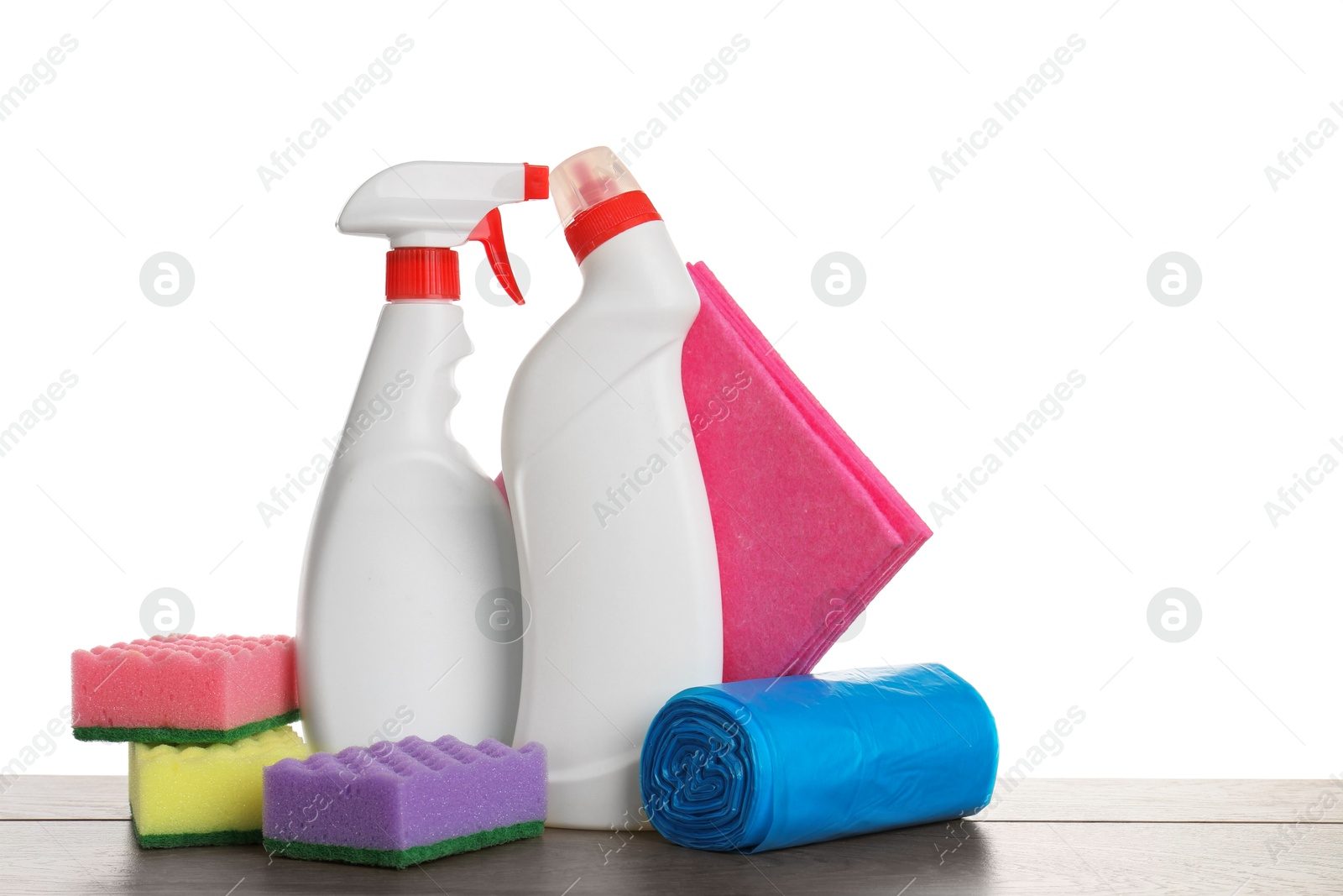 Photo of Different toilet cleaners, sponges, rag and trash bags on wooden table against white background