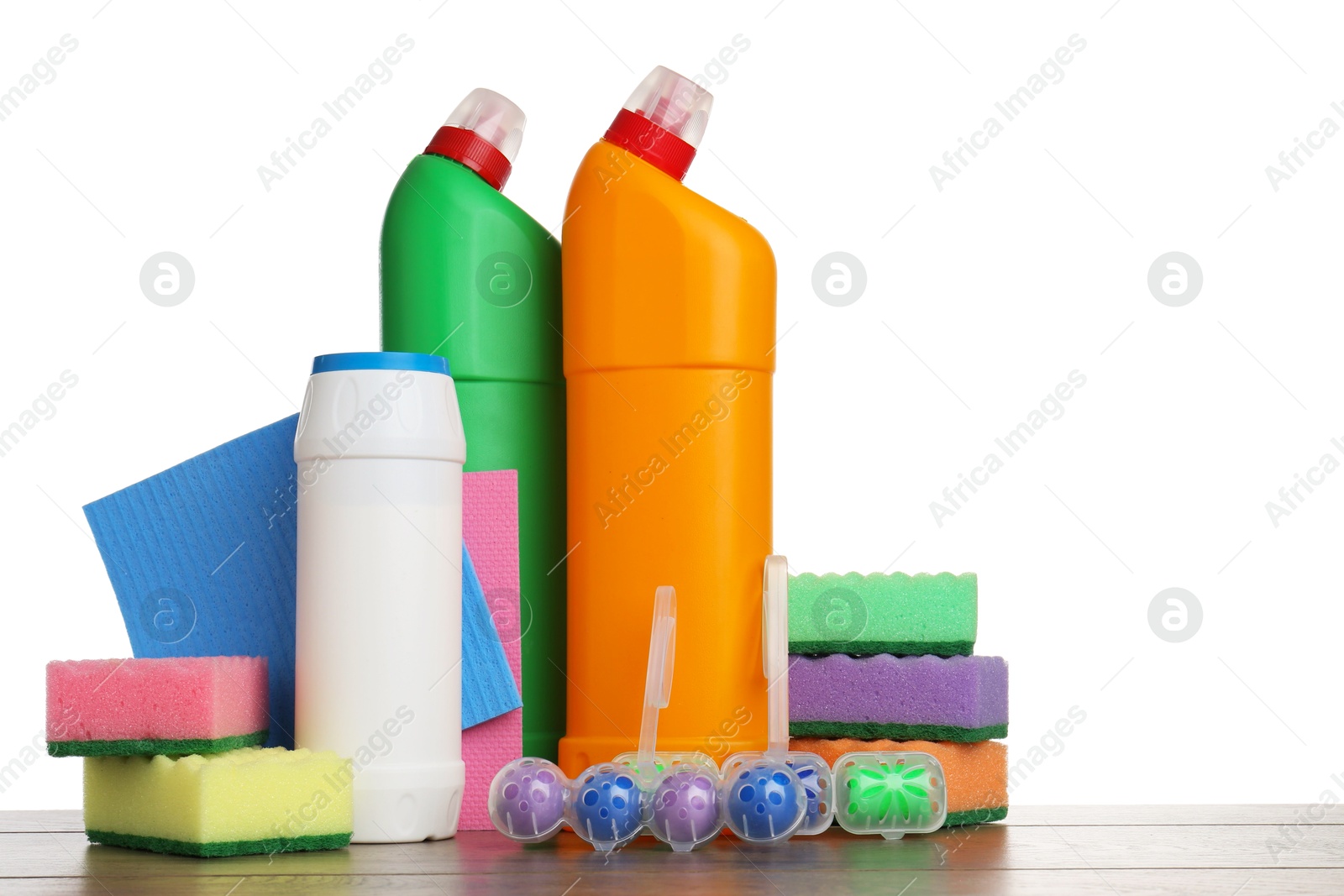 Photo of Different toilet cleaners, sponges and rag on wooden table against white background