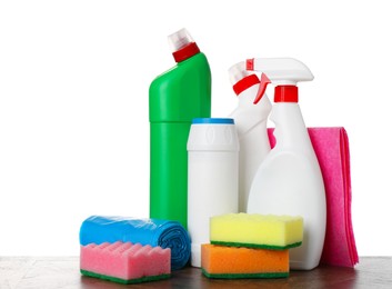 Photo of Different toilet cleaners, sponges, rag and trash bags on wooden table against white background