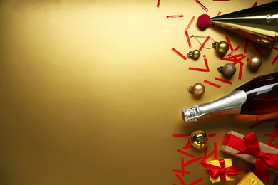 Photo of Flat lay composition with bottle of sparkling wine, confetti and other Christmas decor on beige background. Space for text