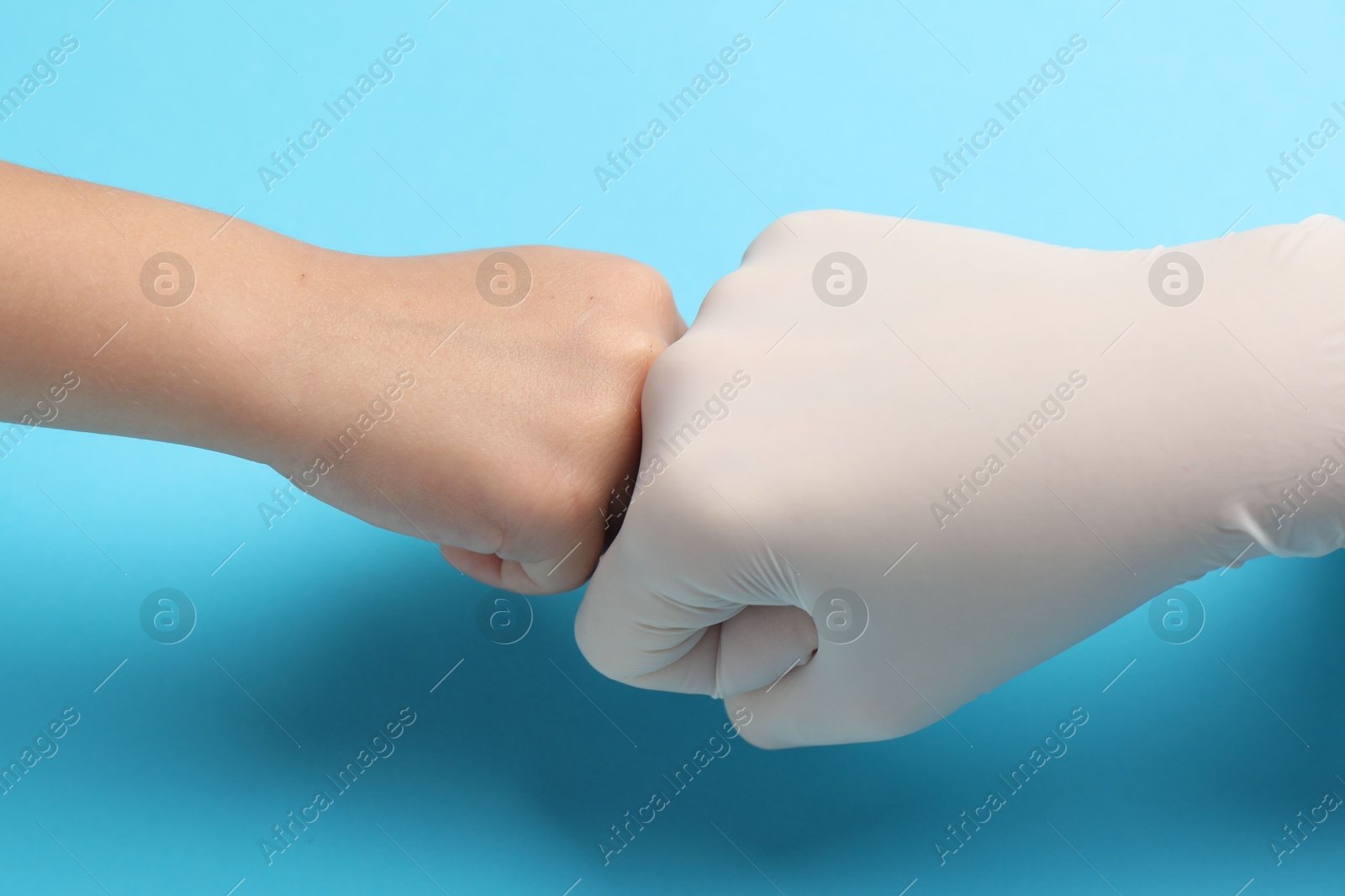 Photo of Doctor and child on light blue background, closeup