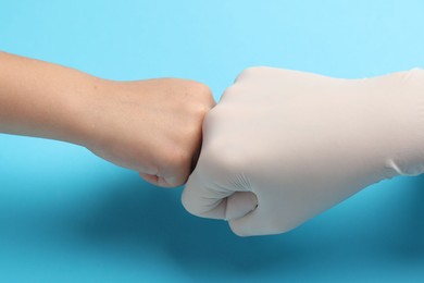 Photo of Doctor and child on light blue background, closeup