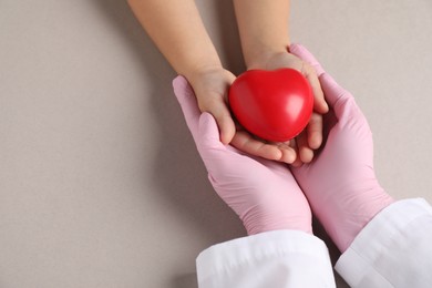 Photo of Doctor and child holding heart model on light grey background, above view. Space for text