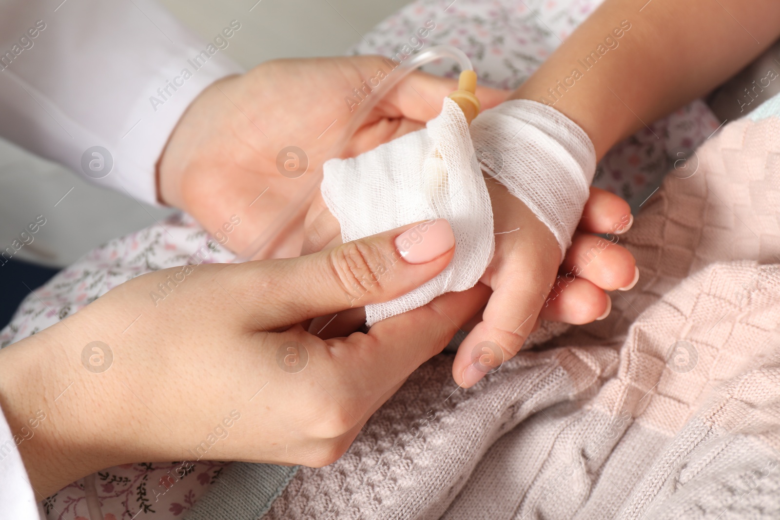 Photo of Doctor and child with intravenous drip at hospital, closeup