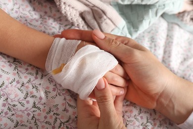 Photo of Doctor and child with intravenous drip at hospital, closeup