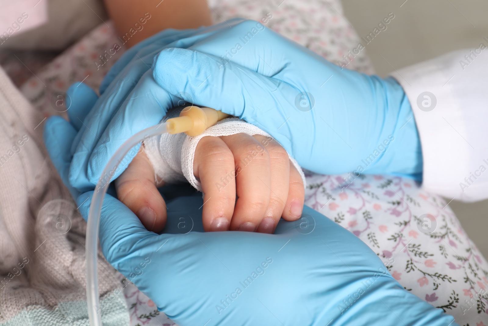 Photo of Doctor and child with intravenous drip at hospital, closeup