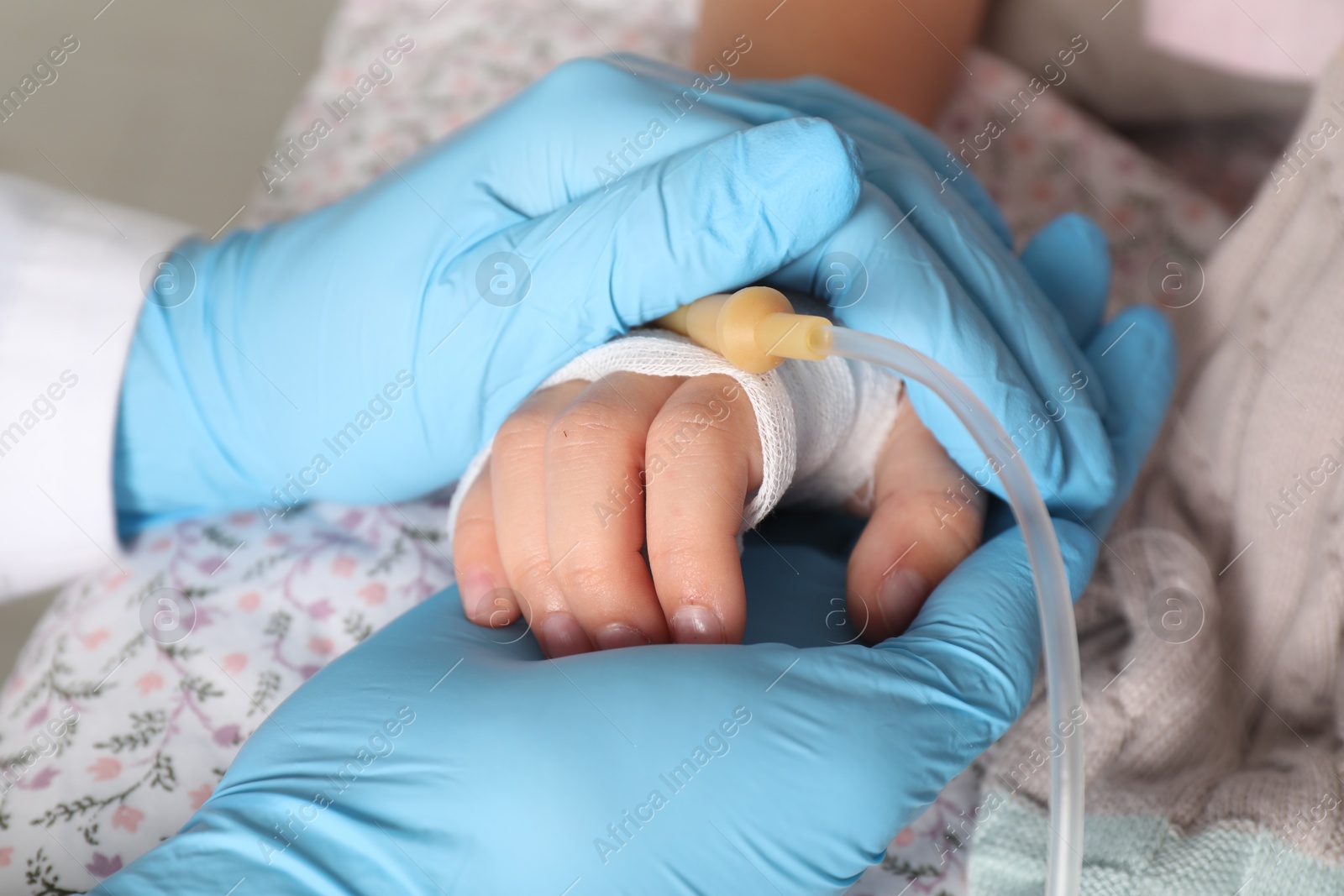 Photo of Doctor and child with intravenous drip at hospital, closeup