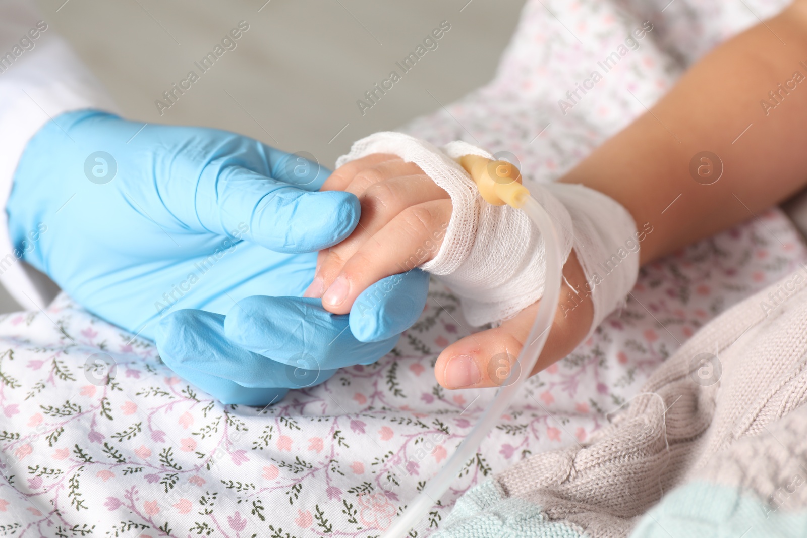 Photo of Doctor and child with intravenous drip at hospital, closeup