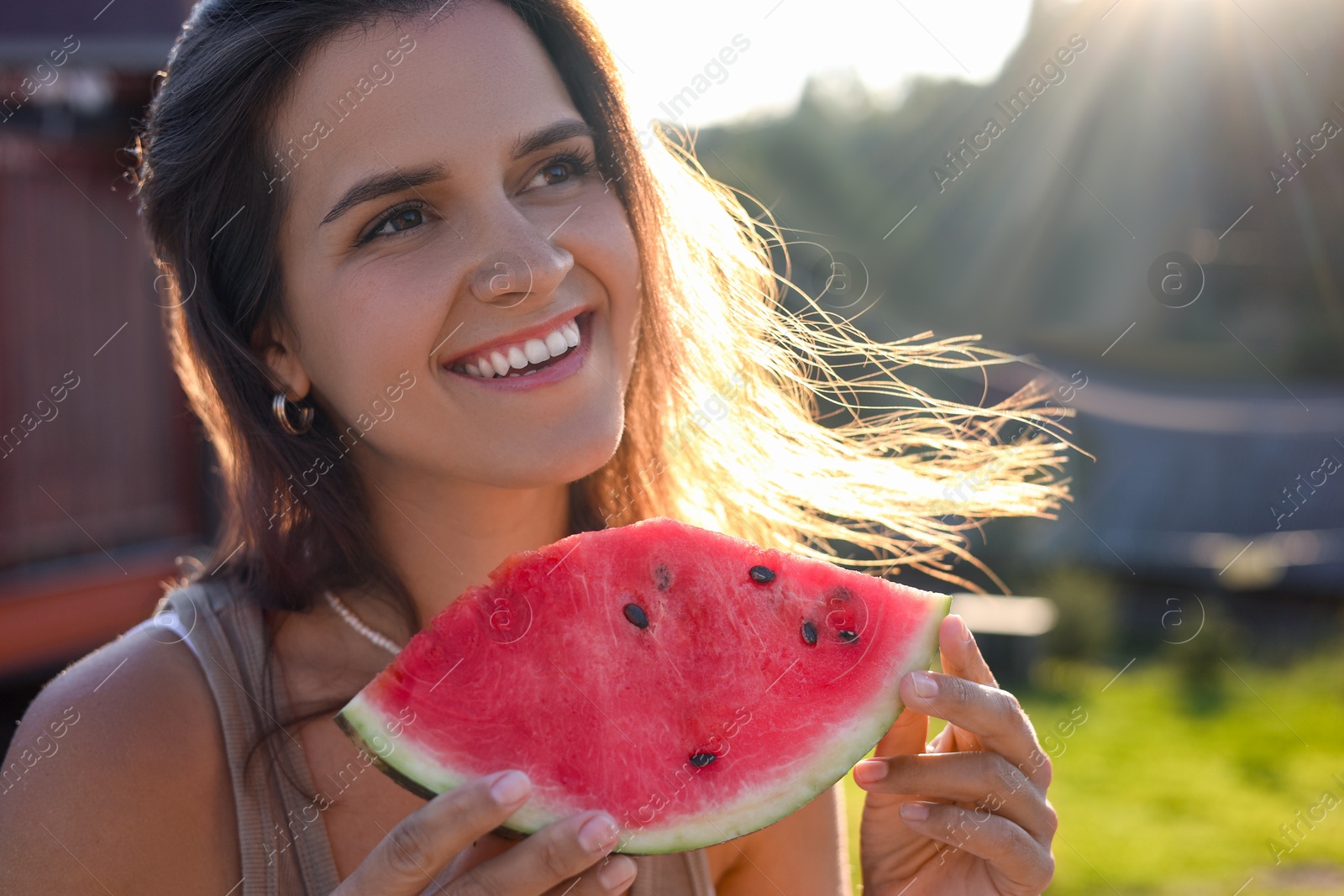 Photo of Happy woman with slice of juicy watermelon outdoors