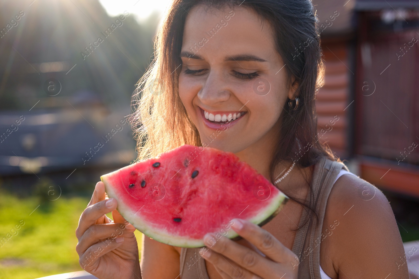 Photo of Happy woman with slice of juicy watermelon outdoors