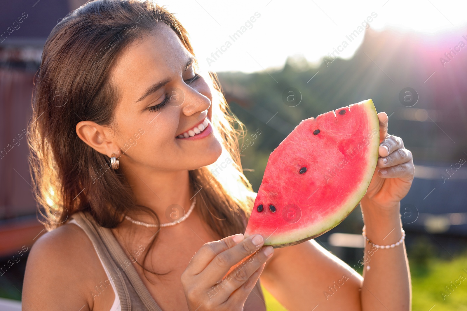 Photo of Happy woman with slice of juicy watermelon outdoors