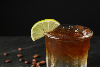 Refreshing espresso tonic drink with slice of lime on dark background, closeup