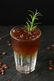 Photo of Refreshing espresso tonic drink with rosemary and coffee beans on dark table