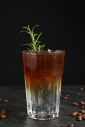 Photo of Refreshing espresso tonic drink with rosemary and coffee beans on dark table