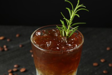 Photo of Refreshing espresso tonic drink with rosemary on dark background, closeup