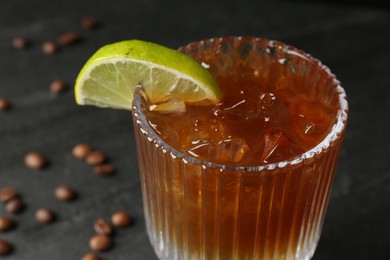 Photo of Refreshing espresso tonic drink with slice of lime on dark background, closeup