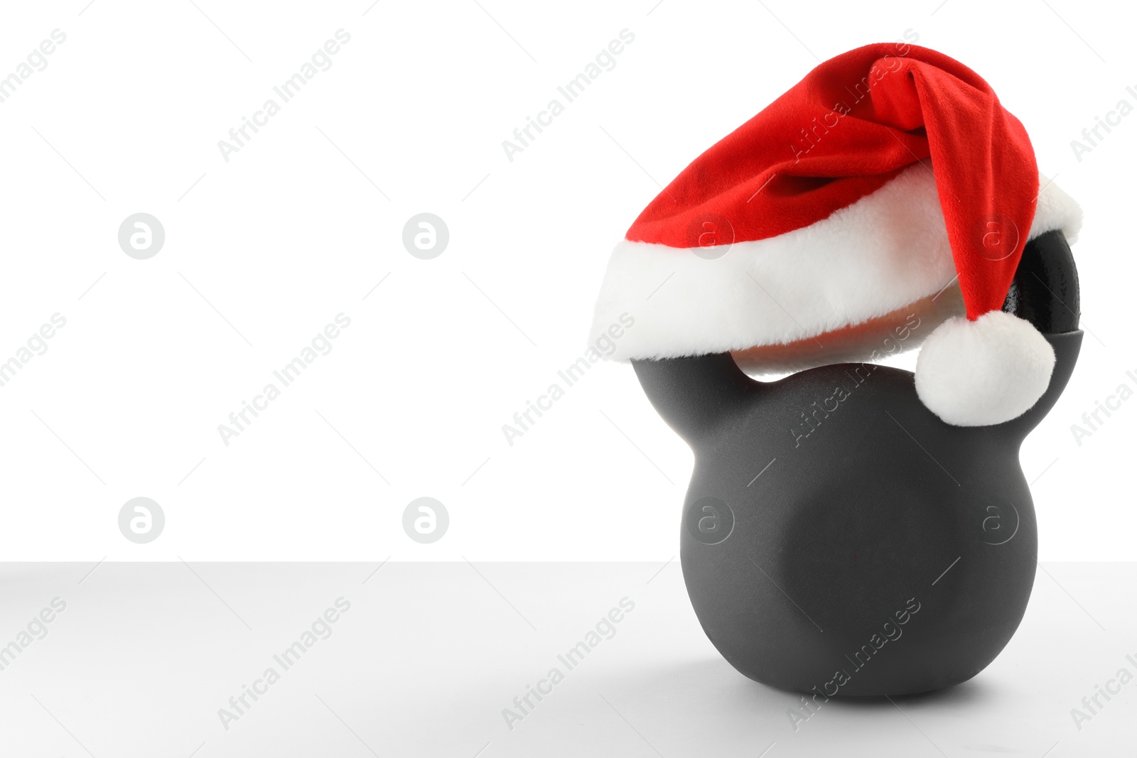 Photo of Kettlebell with red Santa Claus hat isolated on white