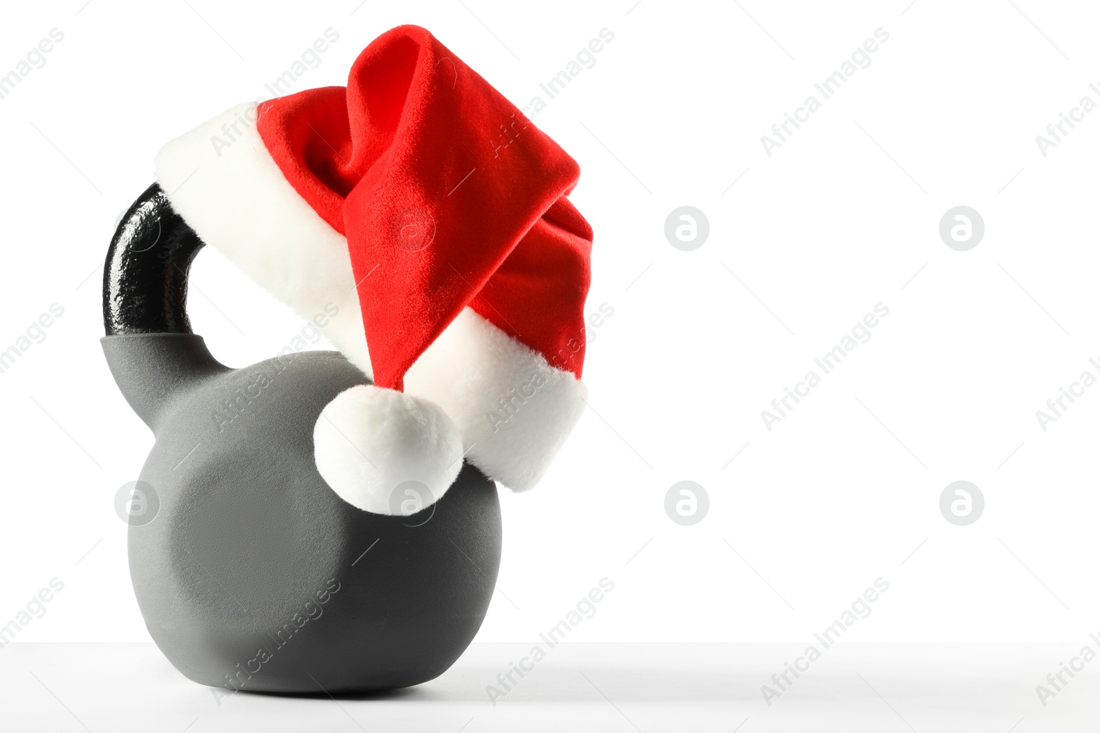 Photo of Kettlebell with red Santa Claus hat isolated on white