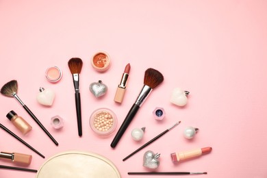 Photo of Cosmetic bag, makeup brushes, decorative cosmetics and Christmas decor on pink background, flat lay