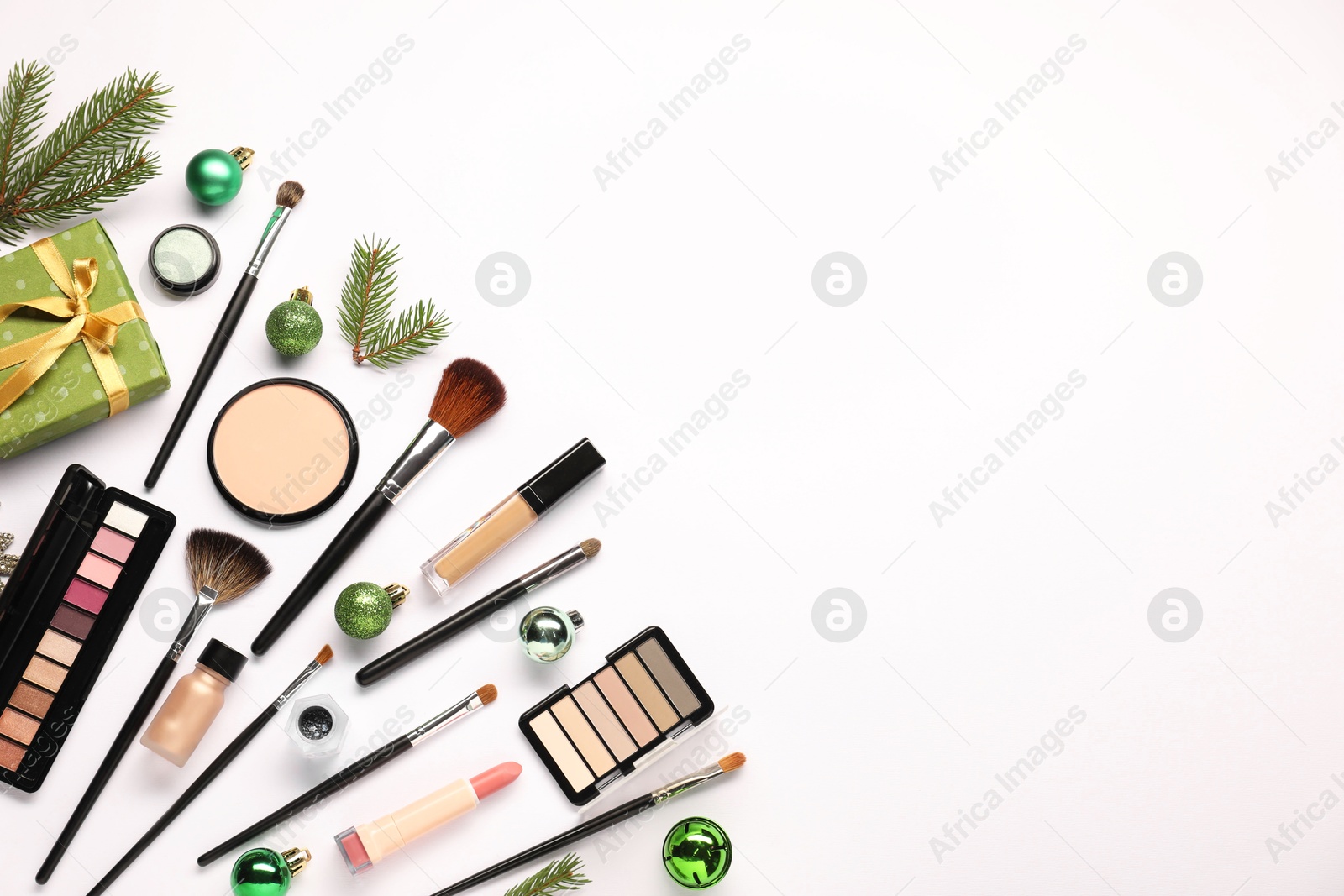 Photo of Different makeup brushes, decorative cosmetics and Christmas decor on white background, flat lay. Space for text