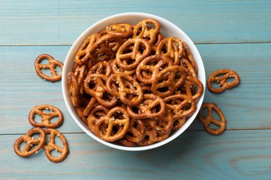 Photo of Tasty pretzel crackers on light blue wooden table, top view