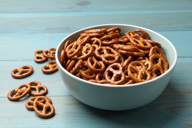 Photo of Tasty pretzel crackers on light blue wooden table, closeup