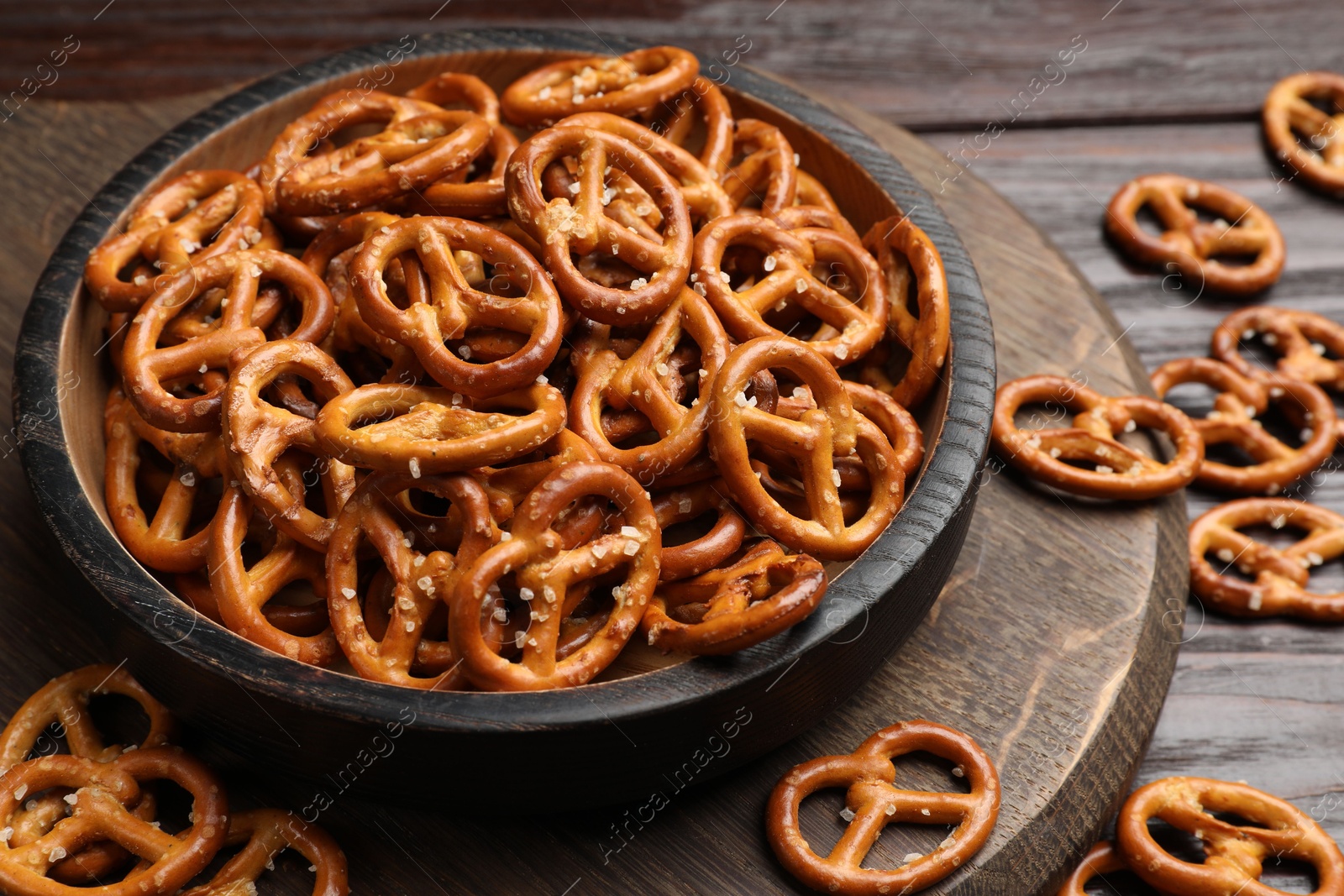 Photo of Tasty pretzel crackers on wooden table, closeup