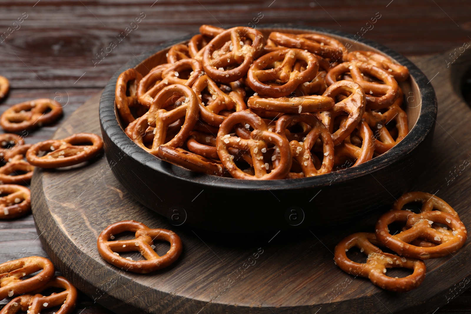 Photo of Tasty pretzel crackers on wooden table, closeup