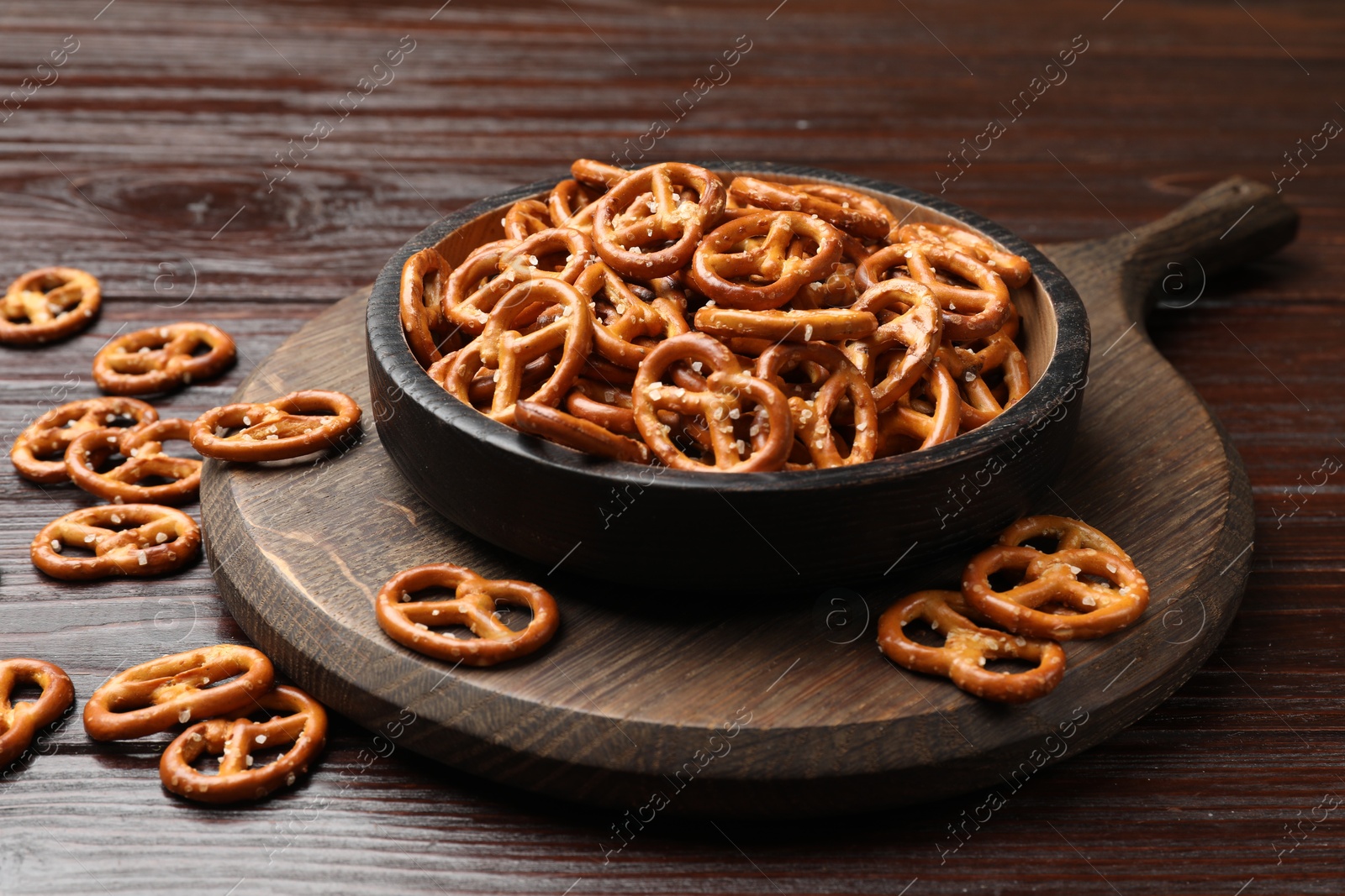 Photo of Tasty pretzel crackers on wooden table, closeup