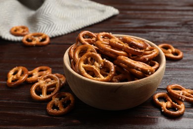 Photo of Tasty pretzel crackers on wooden table, closeup