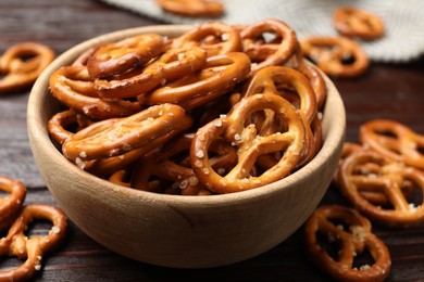 Photo of Tasty pretzel crackers on wooden table, closeup