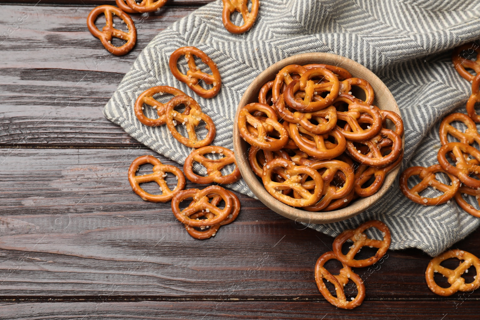 Photo of Tasty pretzel crackers on wooden table, top view. Space for text