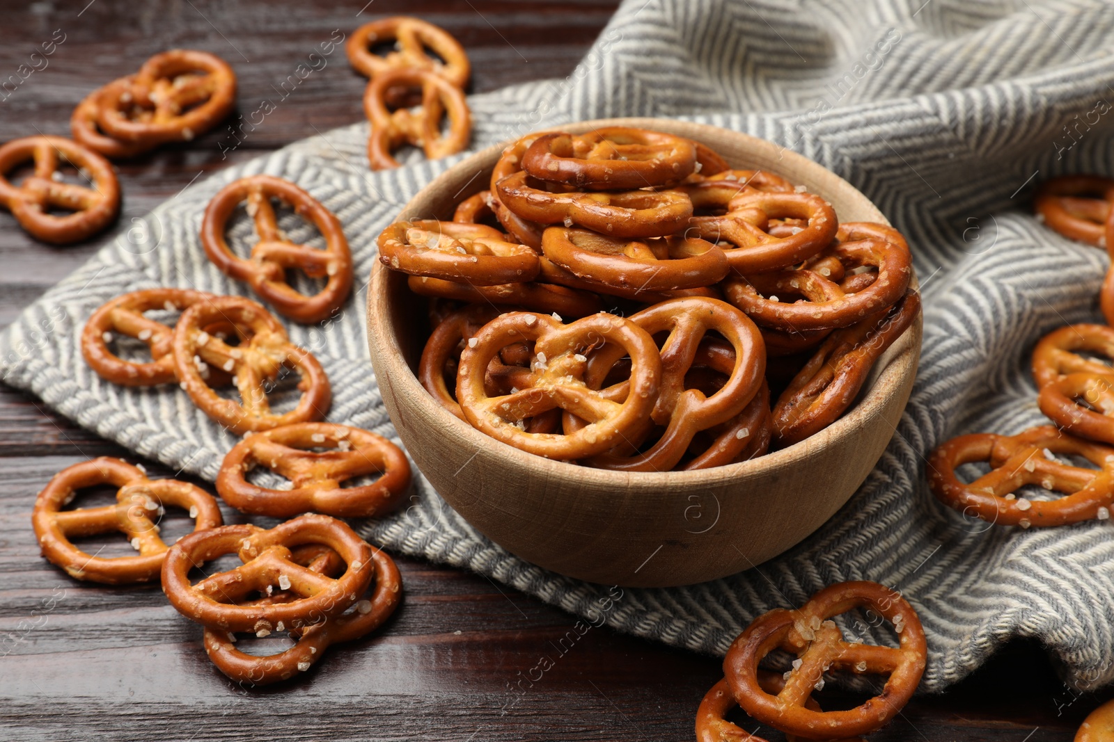 Photo of Tasty pretzel crackers on wooden table, closeup