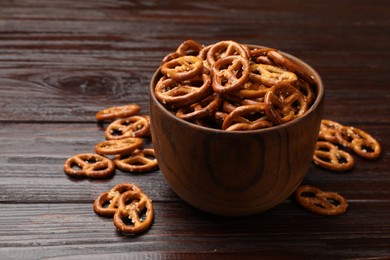 Photo of Tasty pretzel crackers on wooden table, closeup