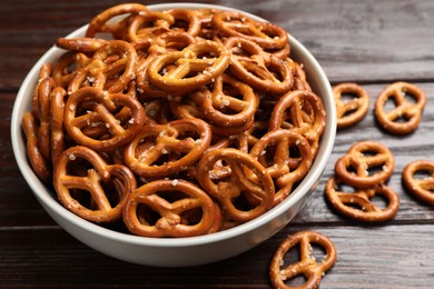 Photo of Tasty pretzel crackers on wooden table, closeup