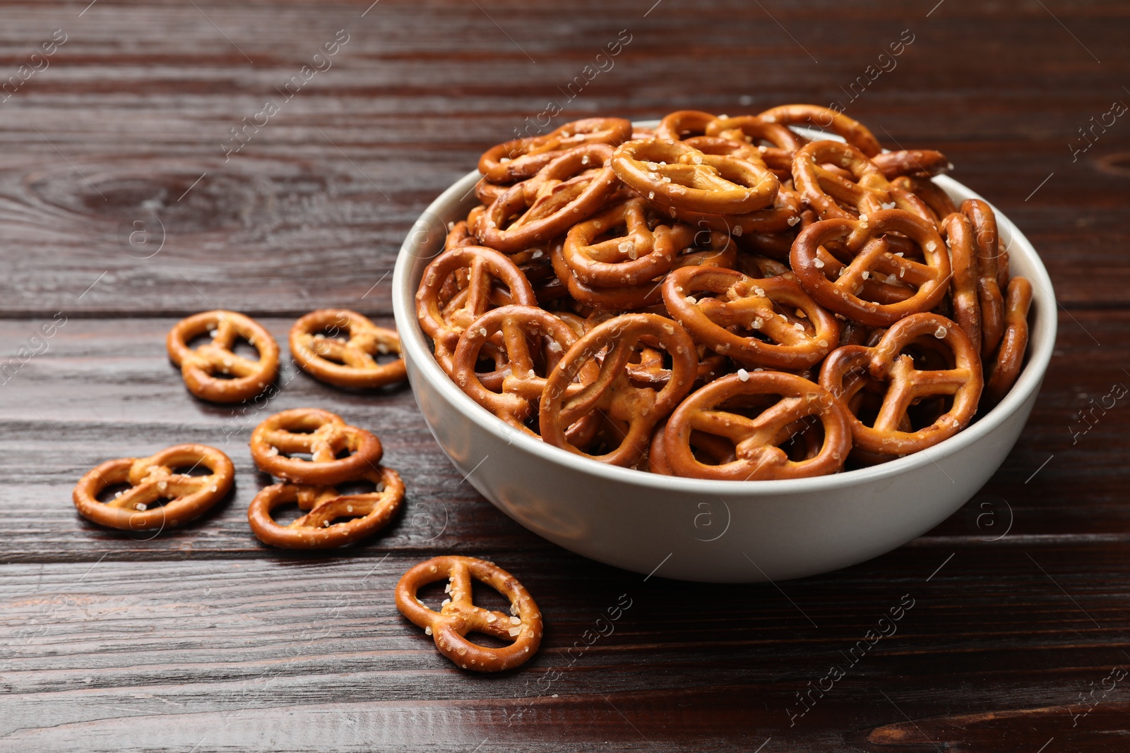 Photo of Tasty pretzel crackers on wooden table, closeup