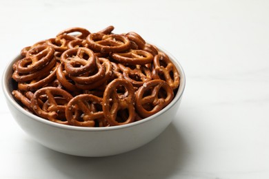 Photo of Tasty pretzel crackers in bowl isolated on white